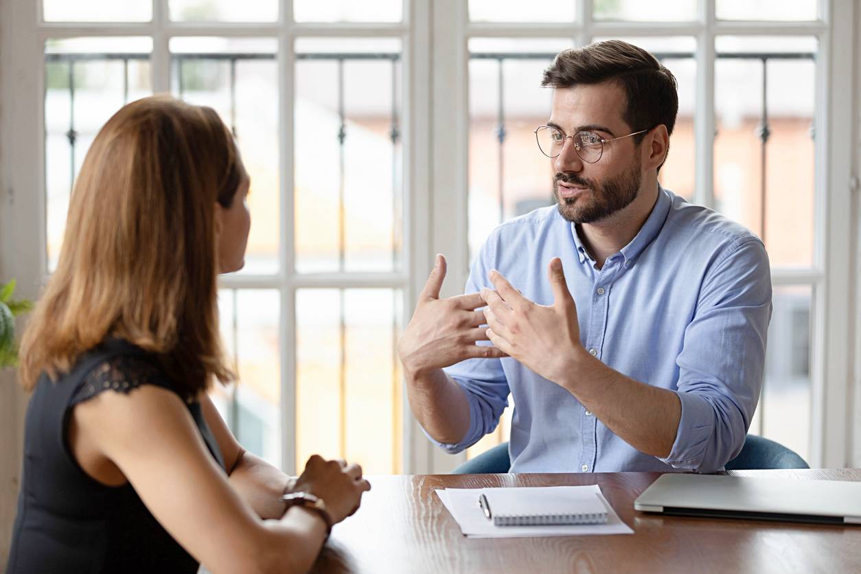 life coach vs career coach - Male life coach actively engaging with a female client during a session