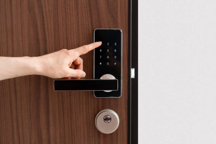 keysmith vs locksmith - Hand using a keypad lock system commonly maintained by locksmiths
