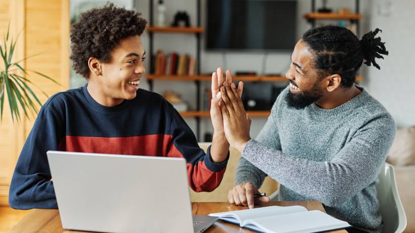 A tutor and student giving each other a high-five after a successful lesson - teacher vs tutor