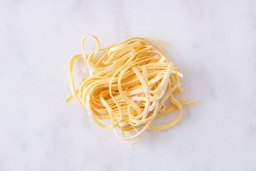 spaghetti vs linguine - Uncooked linguine pasta nests on a marble surface