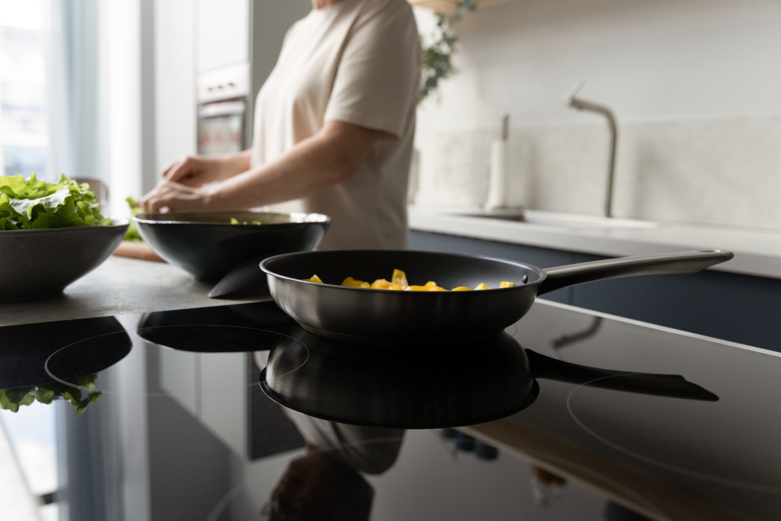 Close-up of ceramic glass cooktop in use while preparing fresh ingredients.