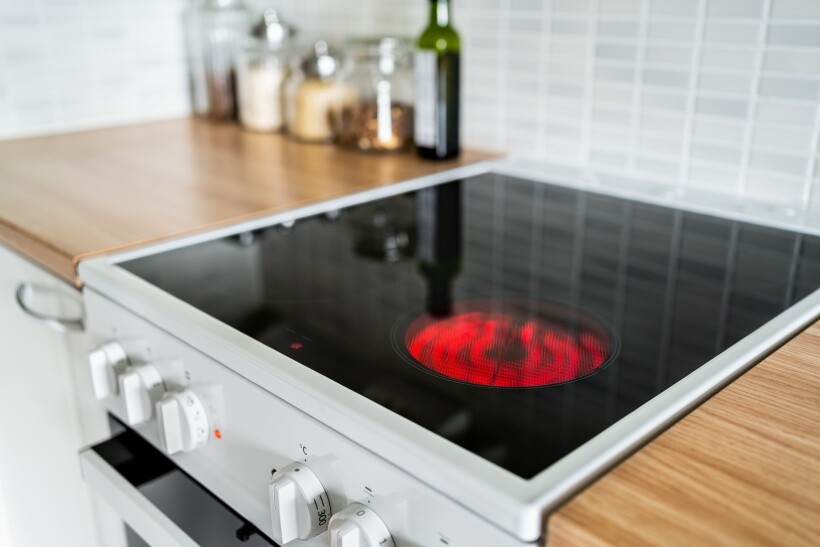 ceramic vs induction cooktop - Modern ceramic cooktop with visible hot burner.