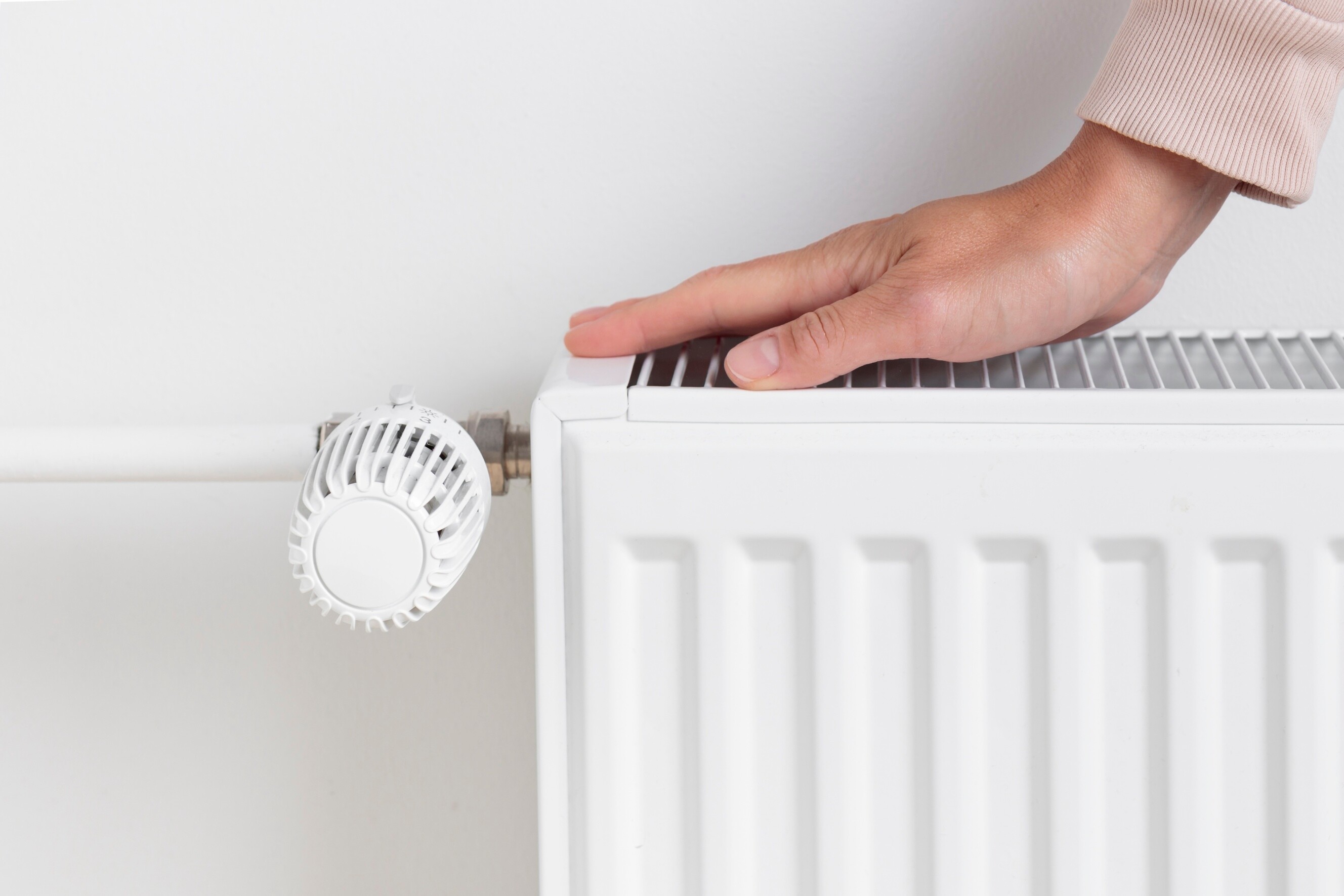 Close-up of a central heating radiator with temperature control valve.