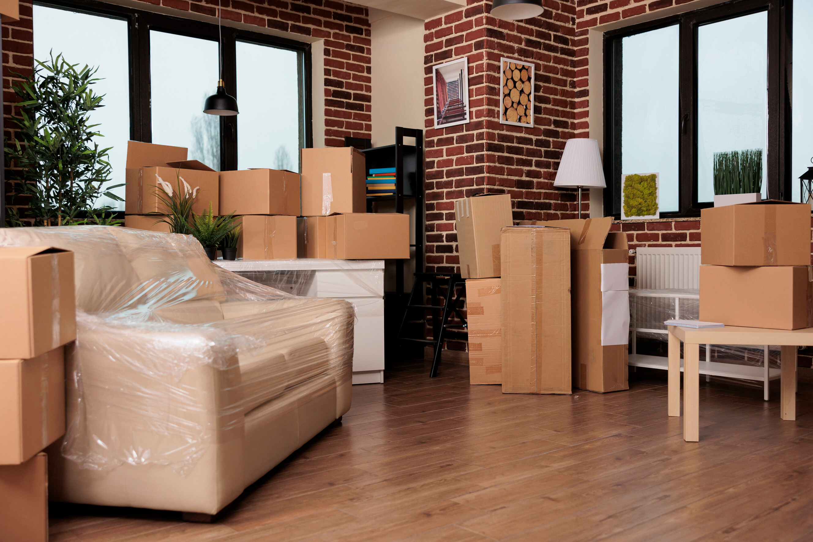 Last-minute moving in progress inside a cosy, brick-walled living space.