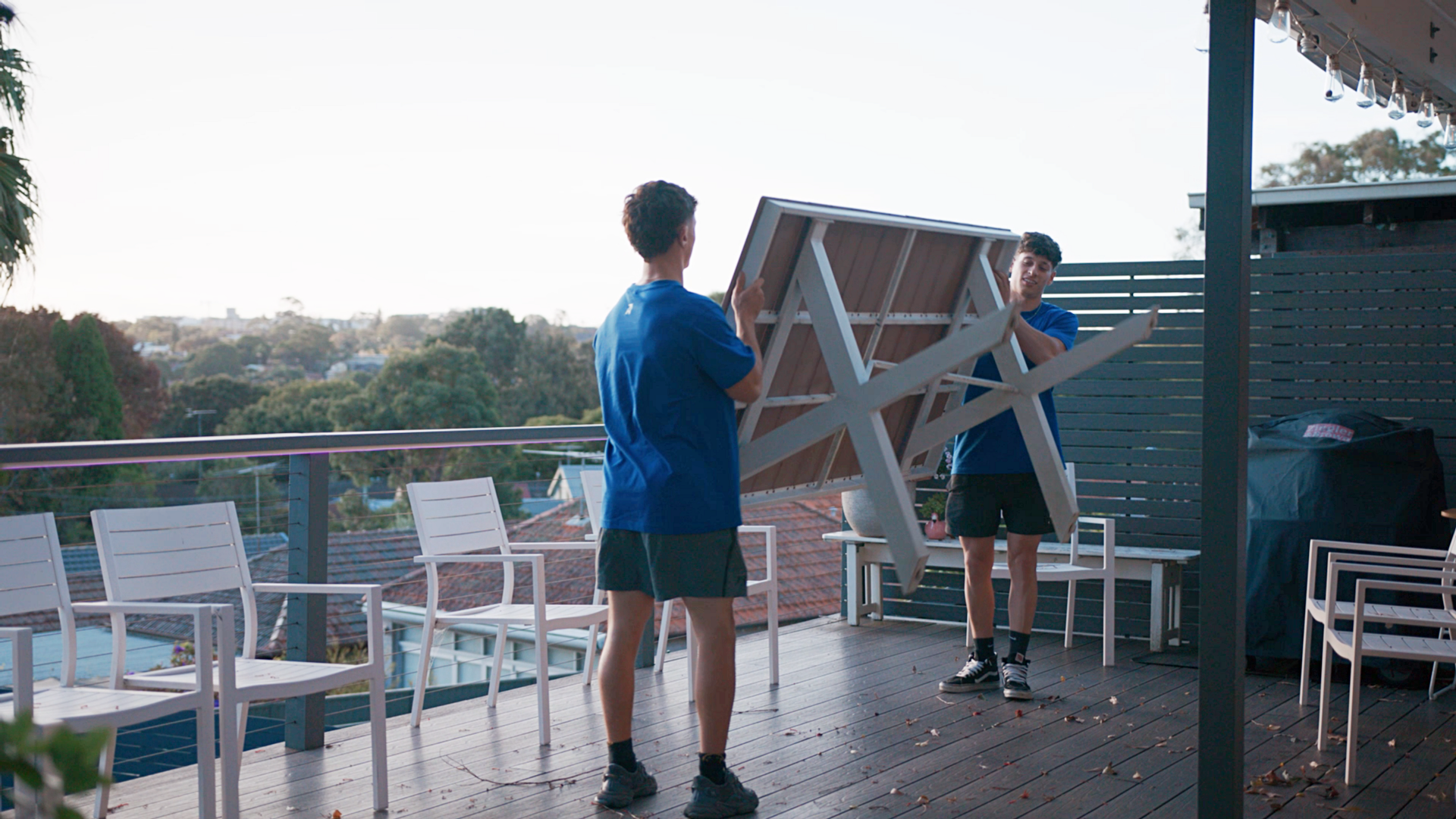 cost to move furniture - Taskers carrying a table across a wooden deck during a move