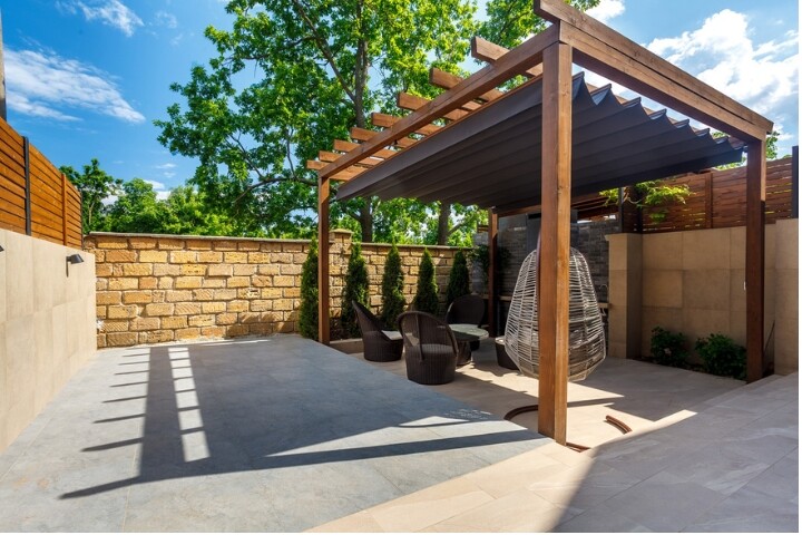 Modern outdoor patio featuring a wooden pergola with a slatted roof 