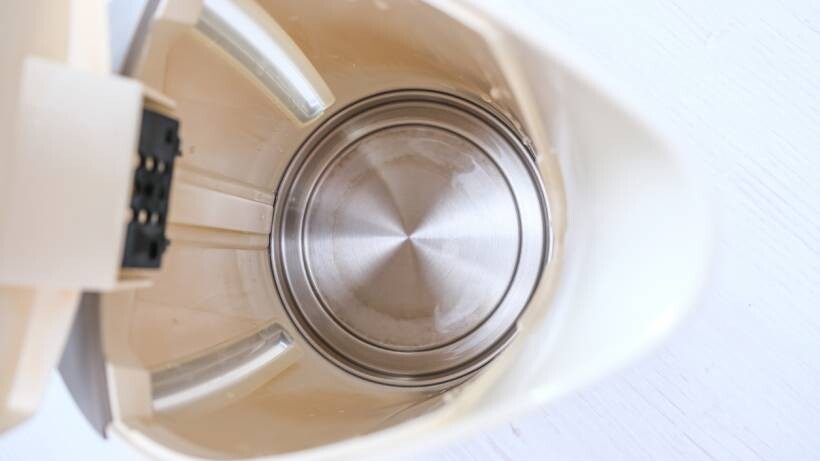 Clean, shiny stainless steel bottom inside a descaled electric kettle - descaling a kettle