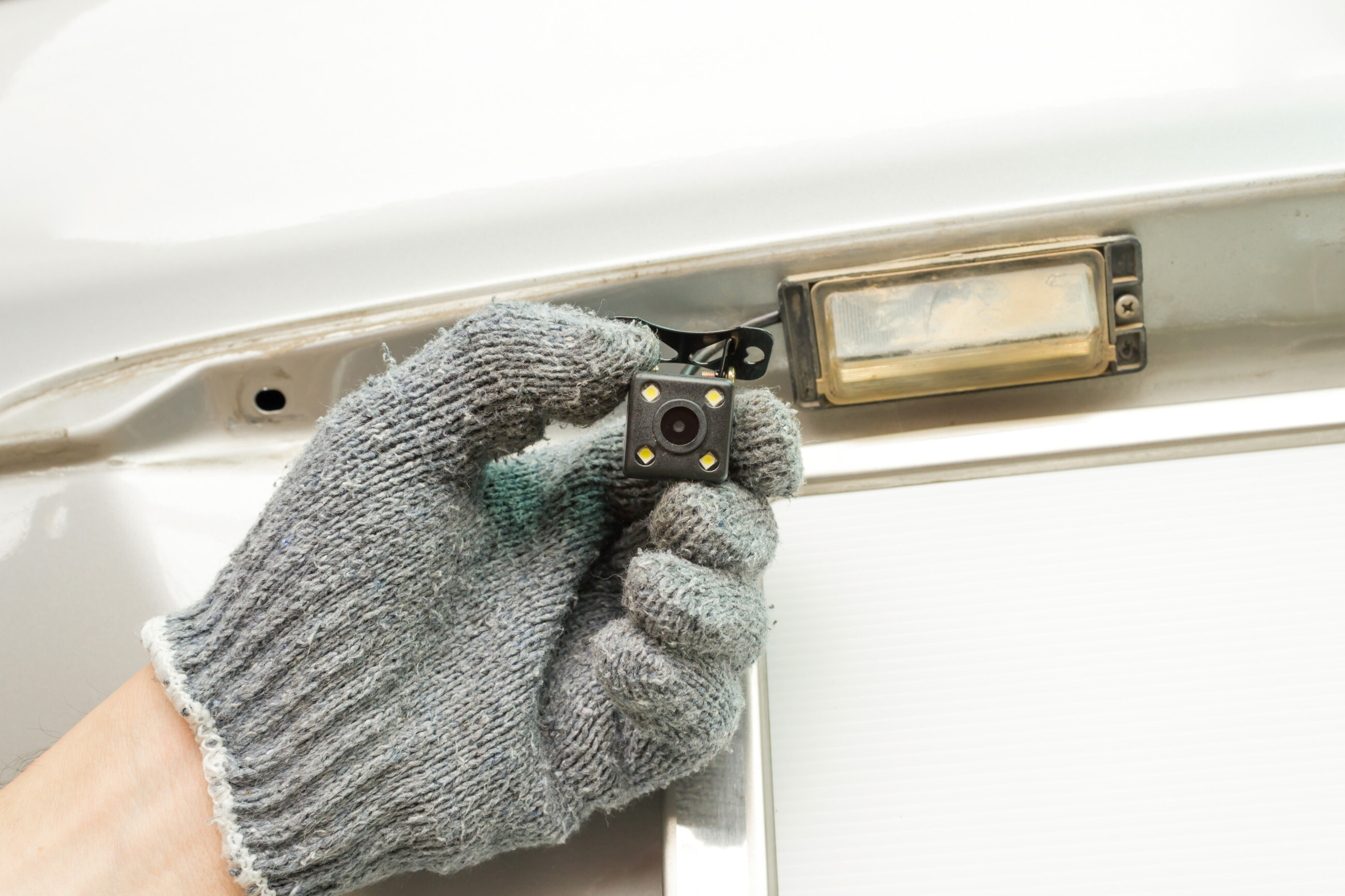 A white van parked on a street, with a person standing next to it, ready to load or unload items.