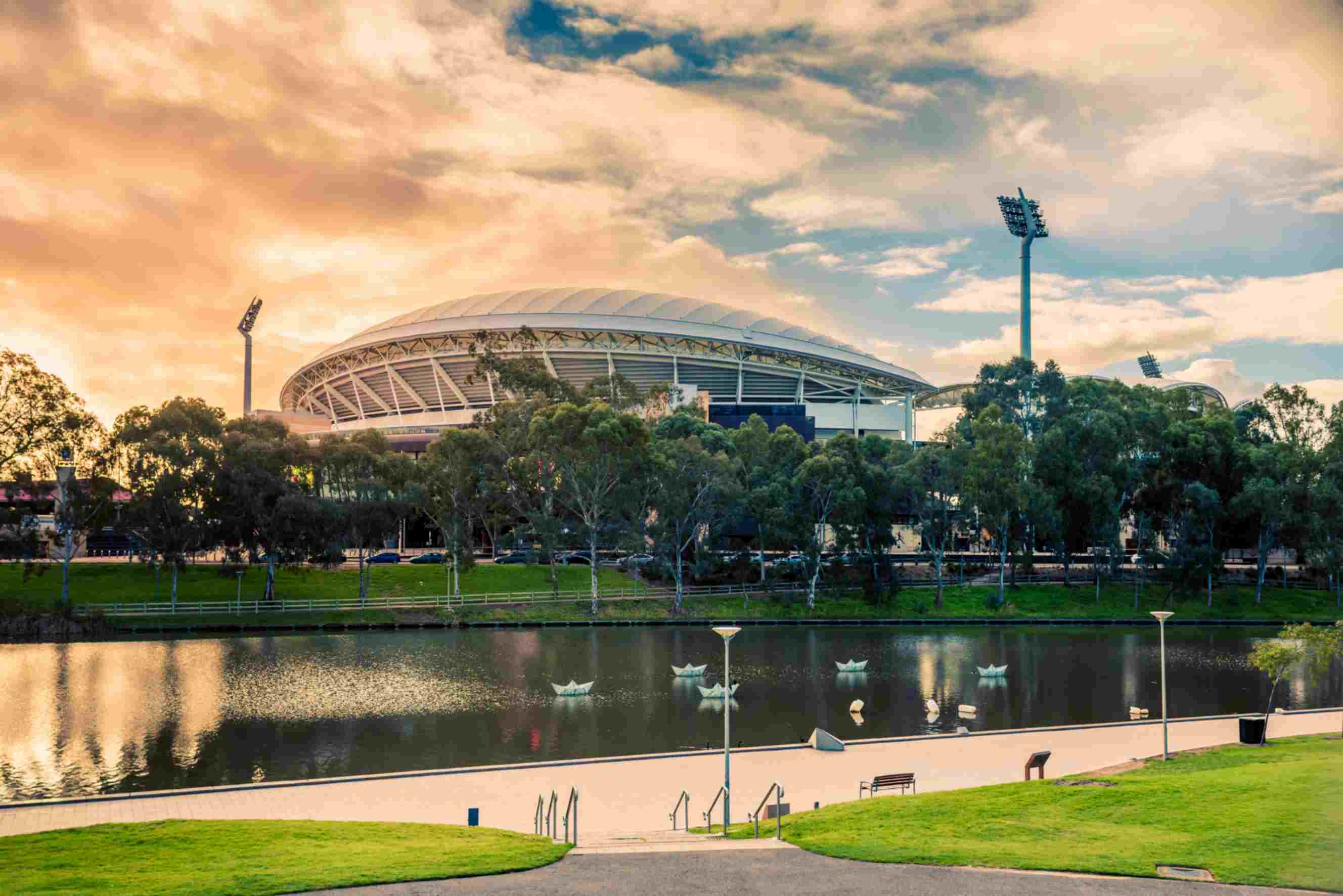 Adelaide Oval stadium at sunset with trees and the River Torrens in the foreground, South Australia