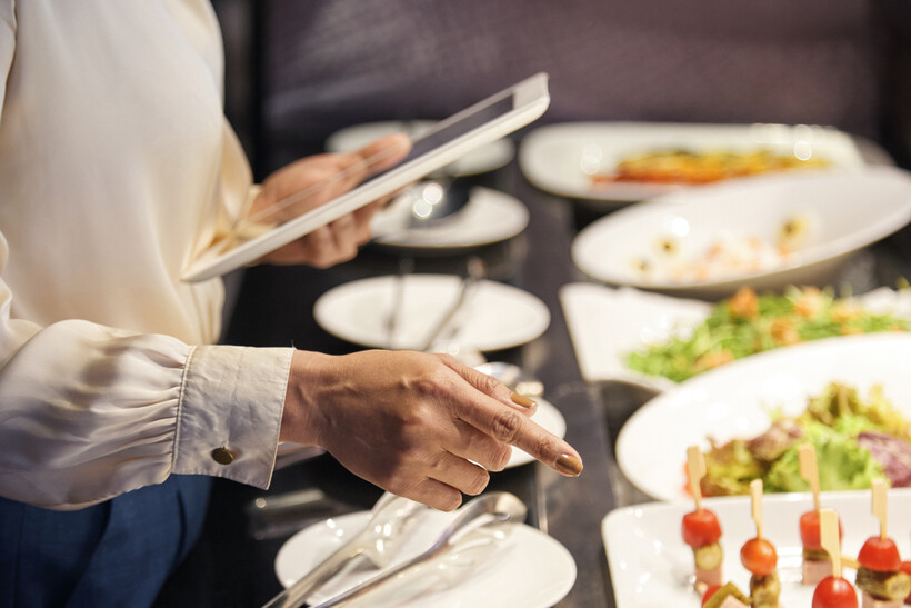 A restaurant manager carefully checking the food quality at a dining station. - plated vs buffet