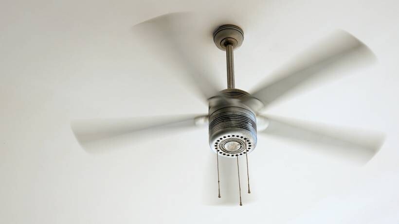 fan vs air conditioner - Sleek ceiling fan spinning to provide effective air circulation in the room