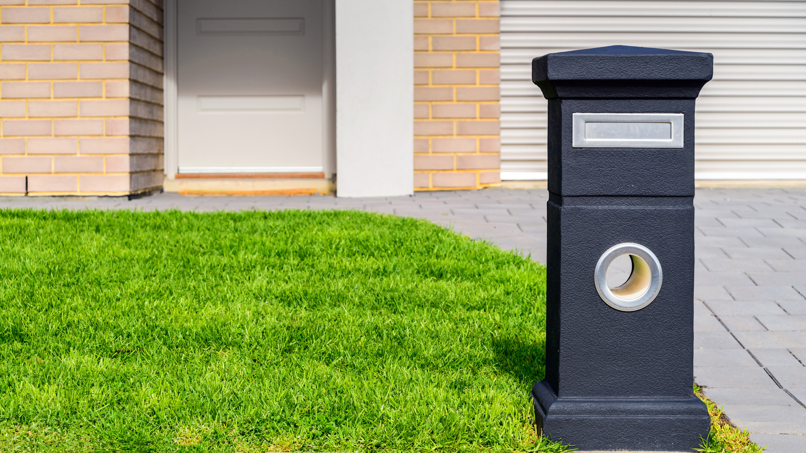 A new freestanding pillar letterbox installed in an Australian front yard.