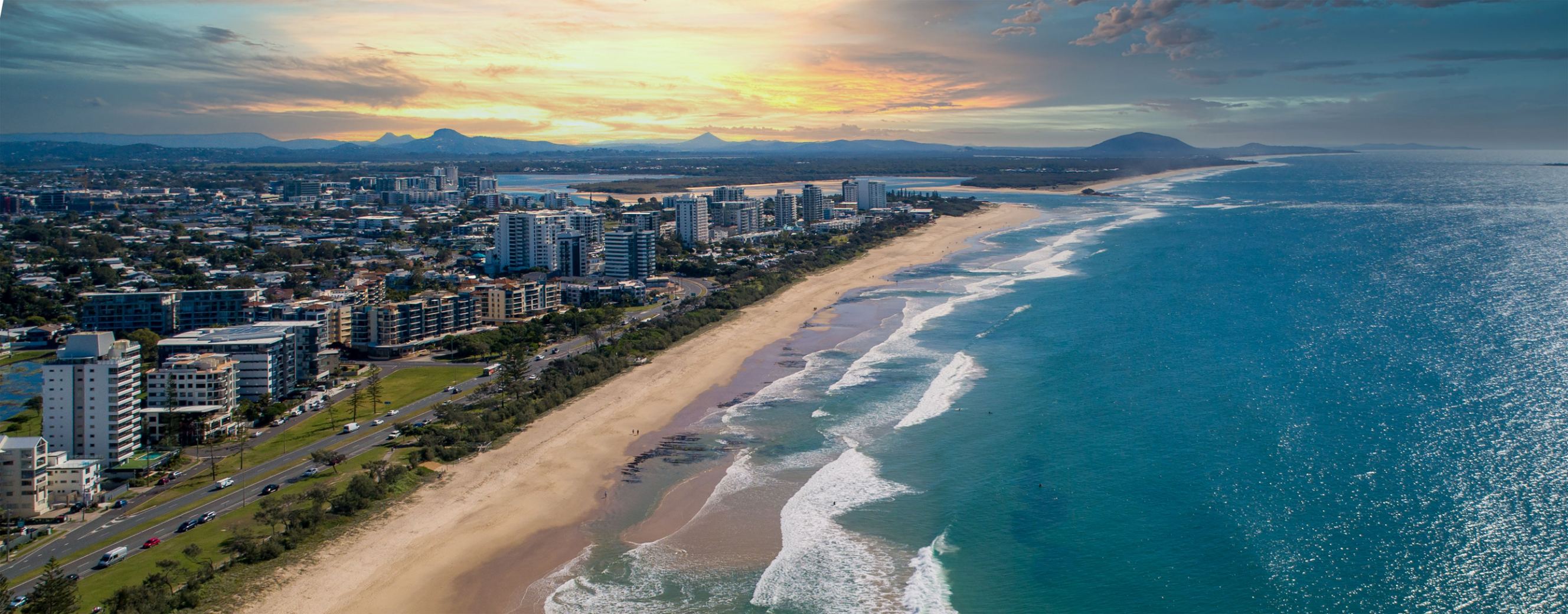 A breathtaking aerial view of the ocean and the city at the sunset in Queensland, Australia symbolizing Melbourne to Sunshine Coast removal services.