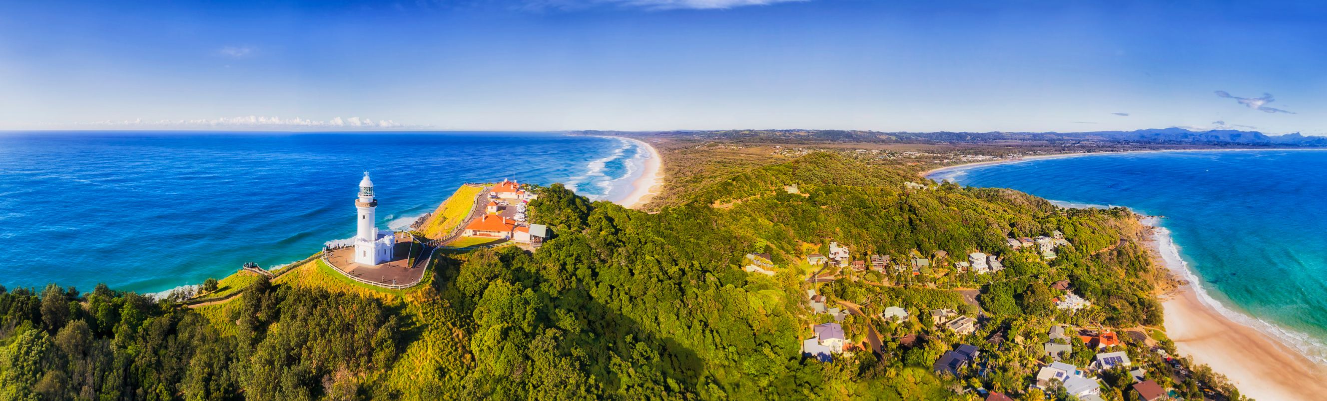 Top of headland with Byron Bay lighthouse high above Pacific ocean coast on a sunny day symbolising Sydney to Bryon Bay removal services.