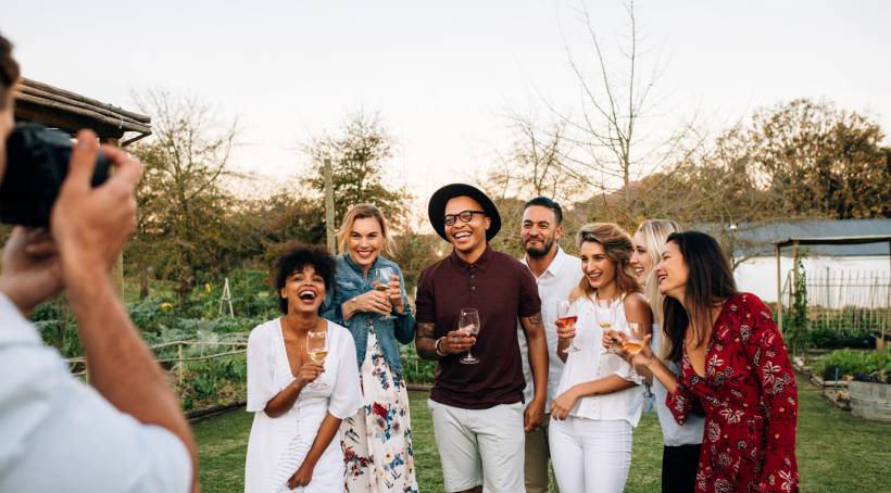 how to make money with photography - People gathered in a garden setting, laughing and posing for a party photographer