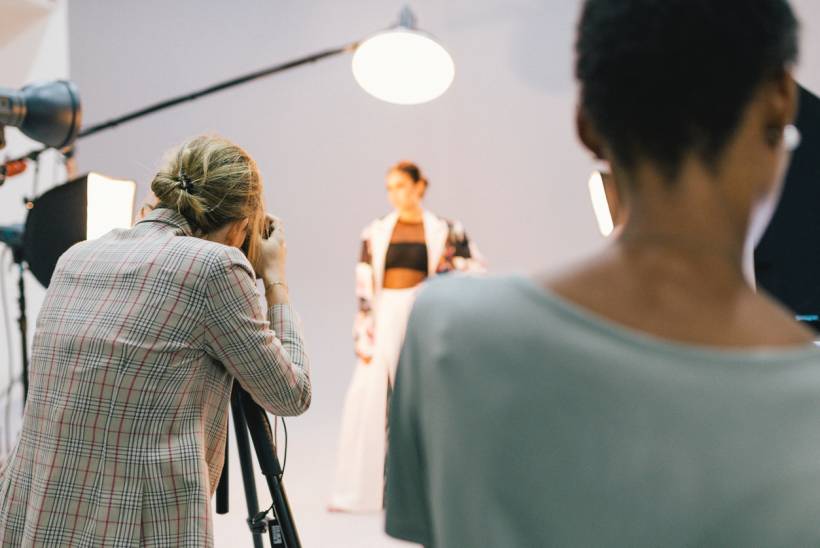 how to make money with photography - Behind-the-scenes view of a fashion photographer capturing a model under studio lighting
