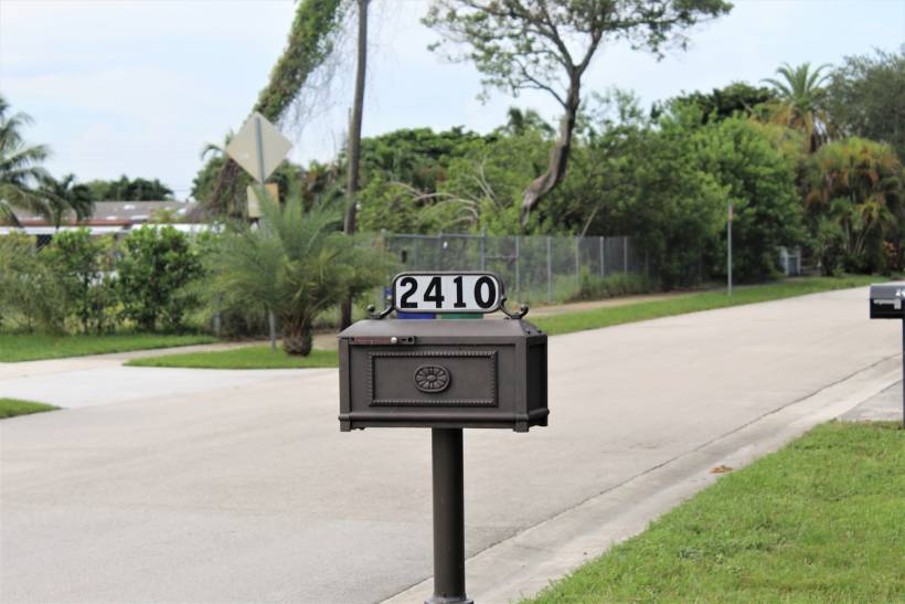 letterbox installation cost - Decorative custom letterbox mounted on a post near a residential street