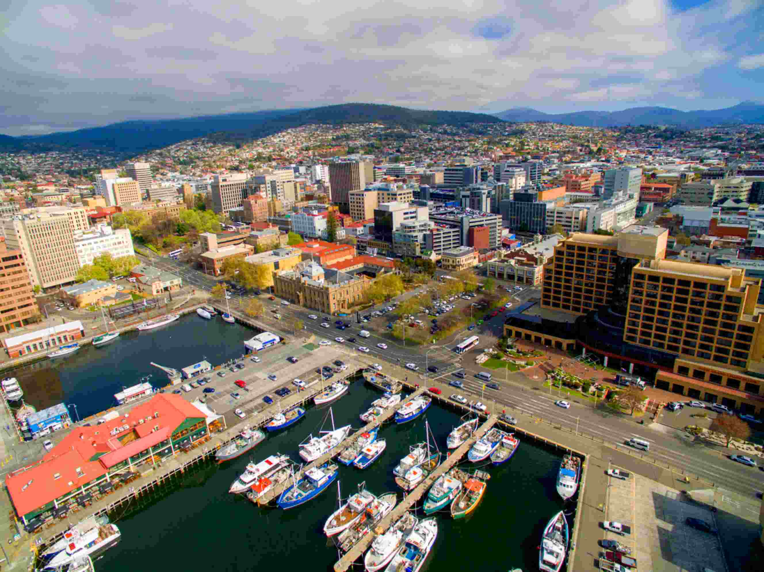 Hobart waterfront with boats and city skyline against mountain backdrop, representing a destination for Brisbane to Hobart relocations