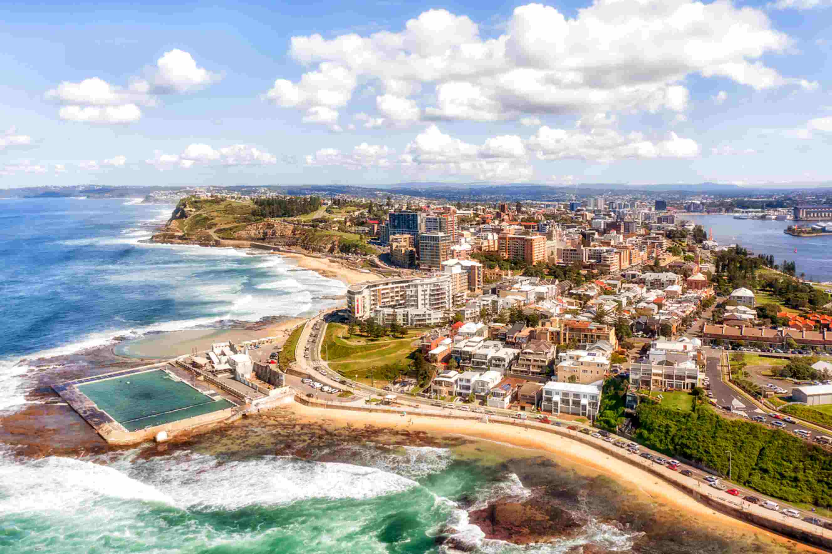 Newcastle coastline with ocean baths and city skyline, representing a popular destination for Melbourne to Newcastle moves