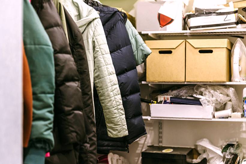 how much does decluttering cost - Cluttered closet with jackets, shelves, and bins