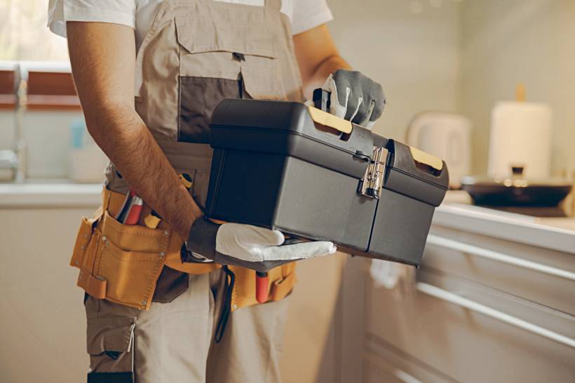 how much does a handyman cost - Home repair professional with toolbox and tool belt