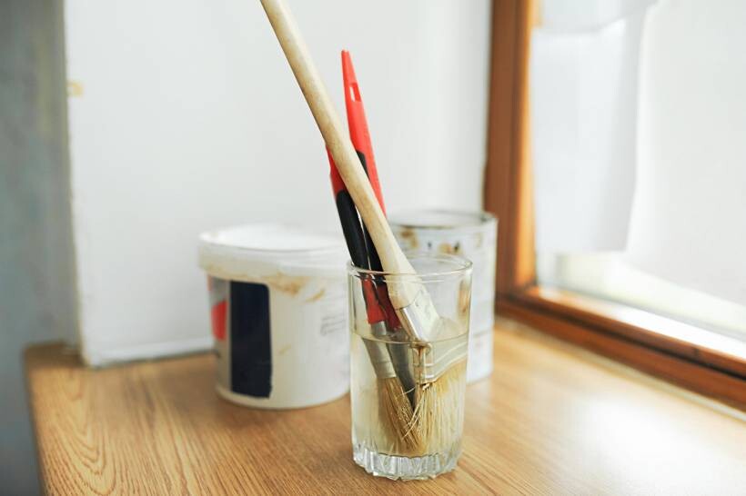 how to limewash walls - Paintbrushes soaking in glass beside paint containers