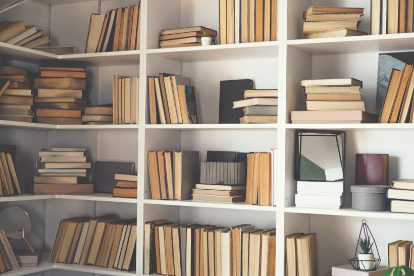 professional organiser cost - White bookshelf with neatly arranged books, decor, and storage items