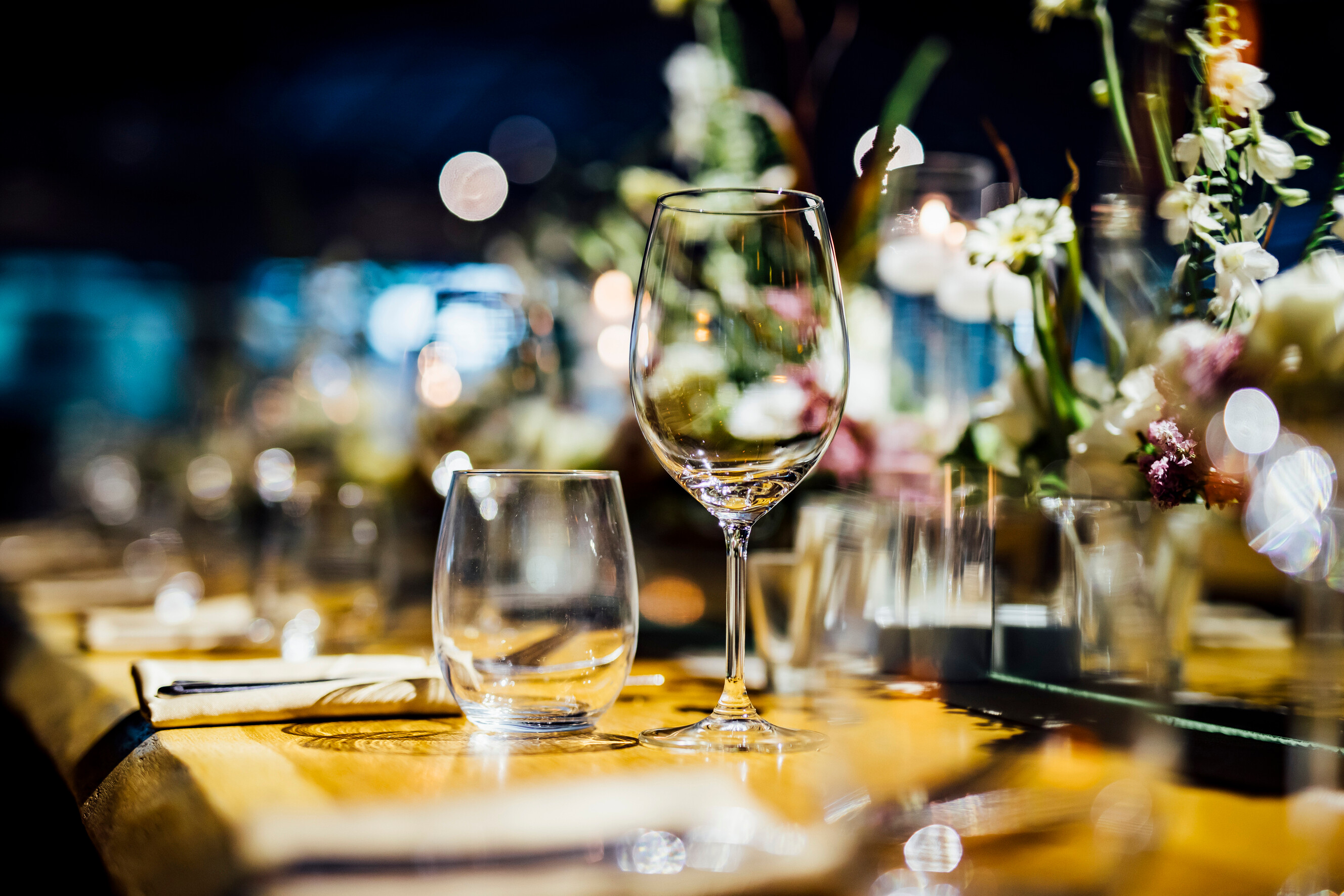 Festive place settings and glassware laid out across a formal dining table.