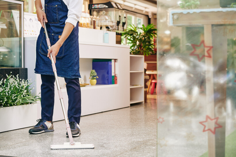 A staff member mopping a shop floor before opening hours. - retail tasks
