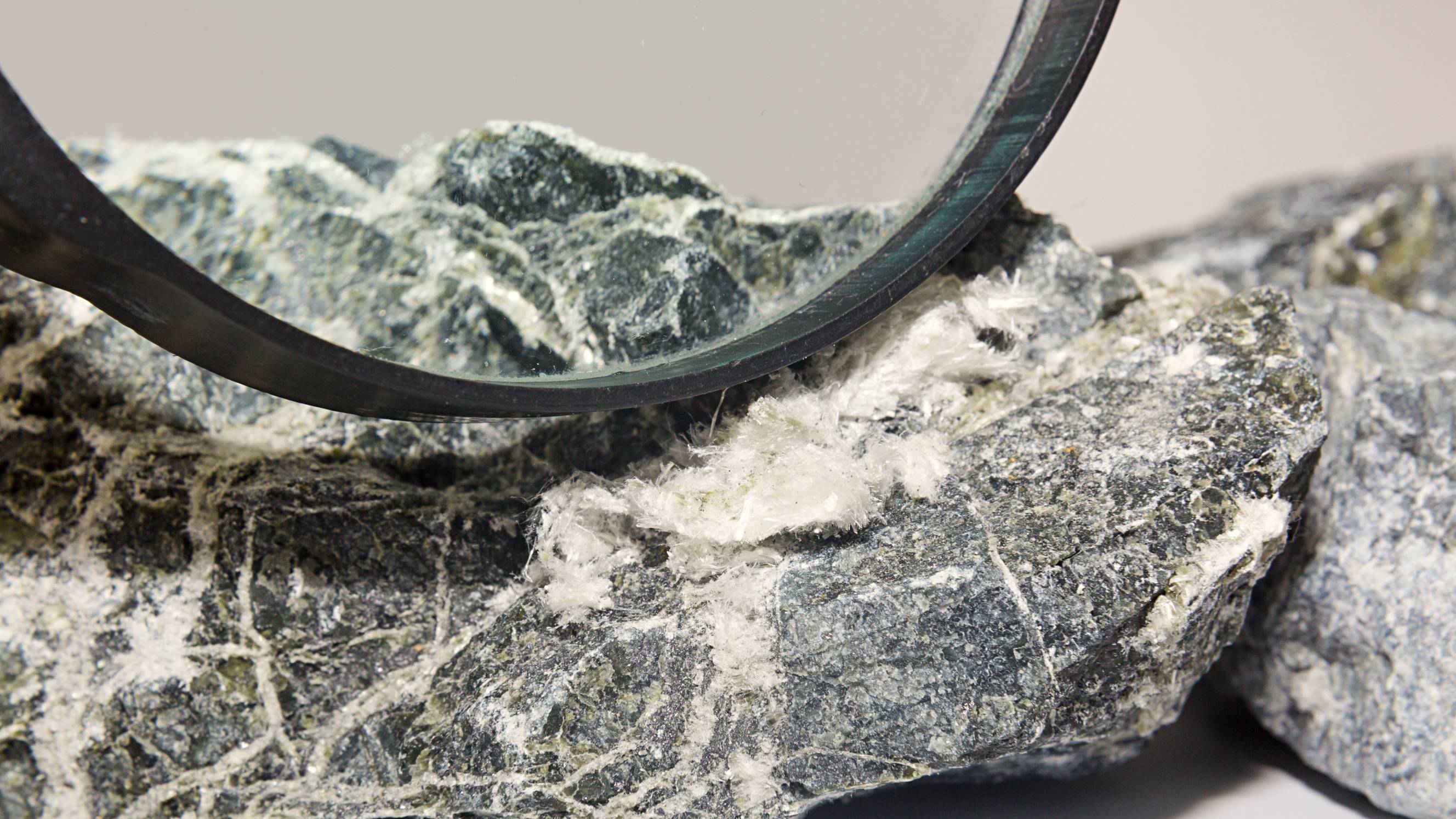 Magnified view of white asbestos-like fibres on a rough stone sample