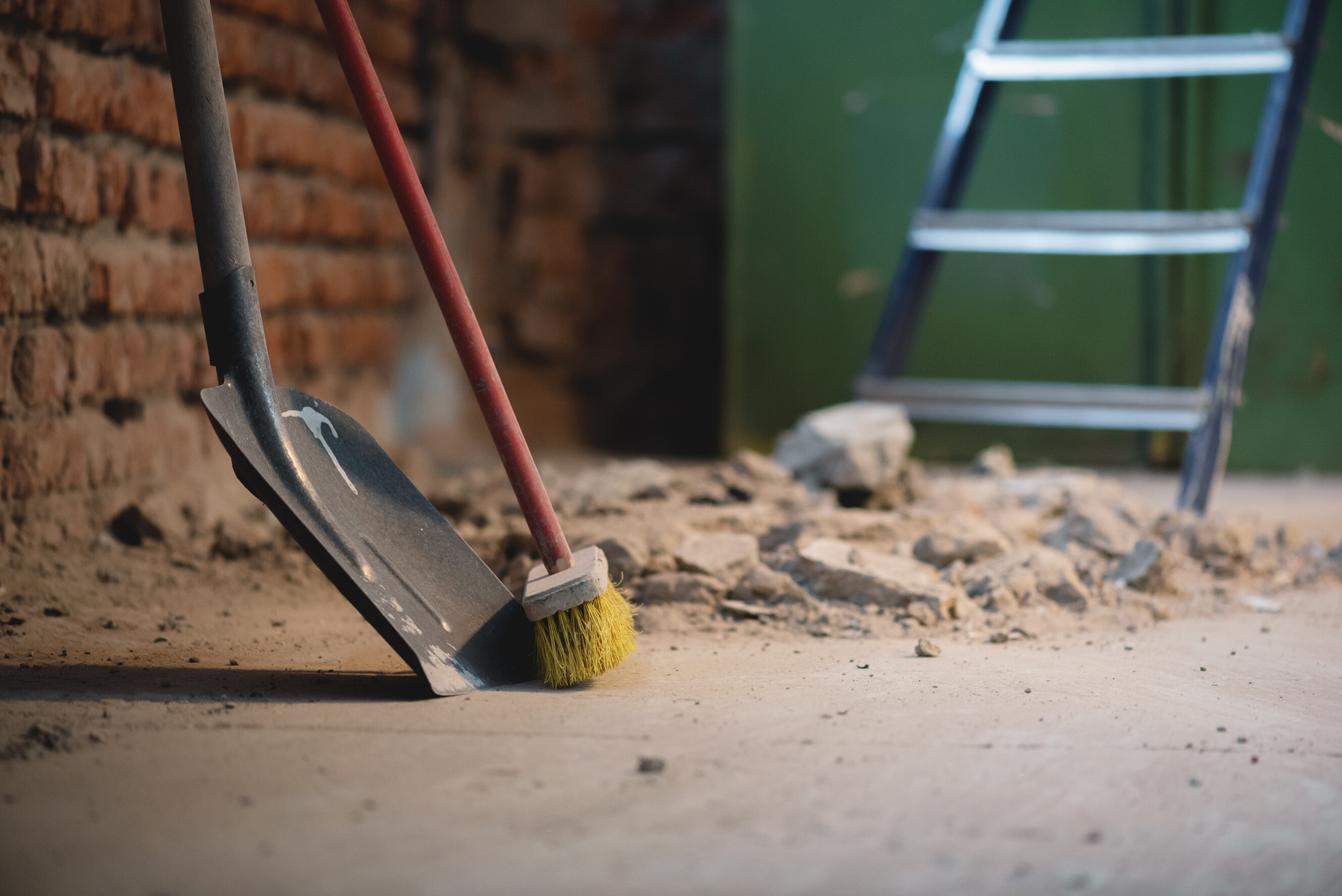 Construction debris and rubbish piled on a renovation site floor awaiting removal.