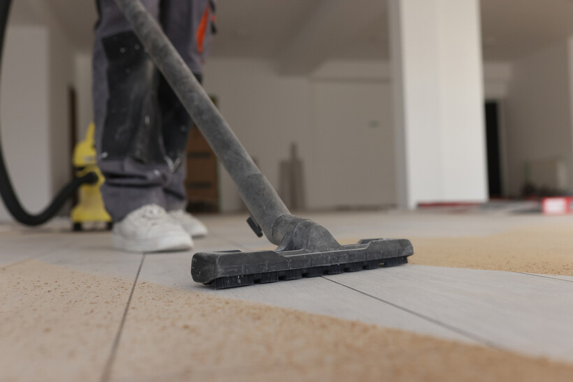 Person using industrial cleaning equipment on a new laminate floor in a renovated room. - after builders cleaning