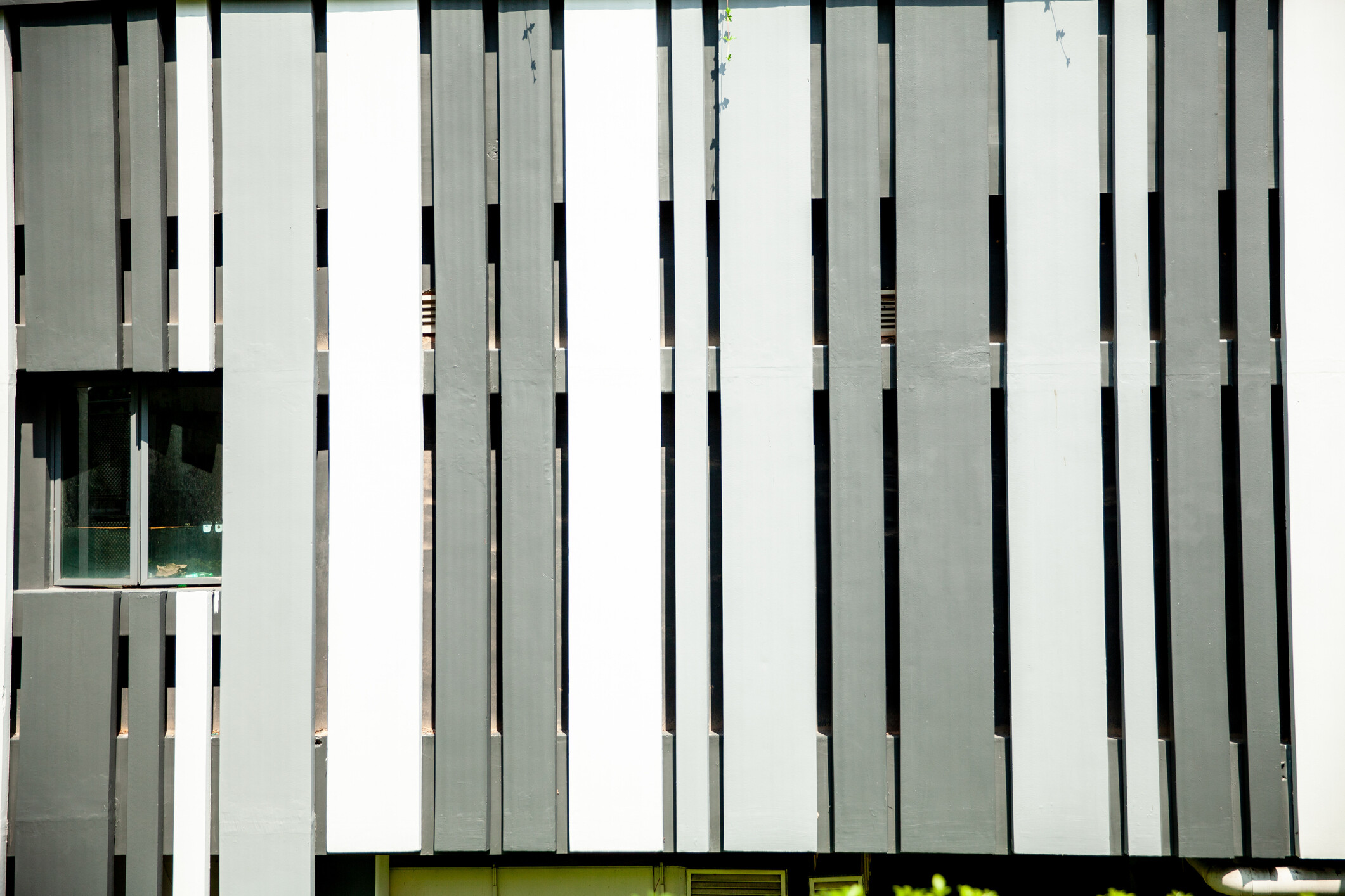 A close-up of vertical boundary slats painted in a minimalist monochrome pattern. - garden fencing cost