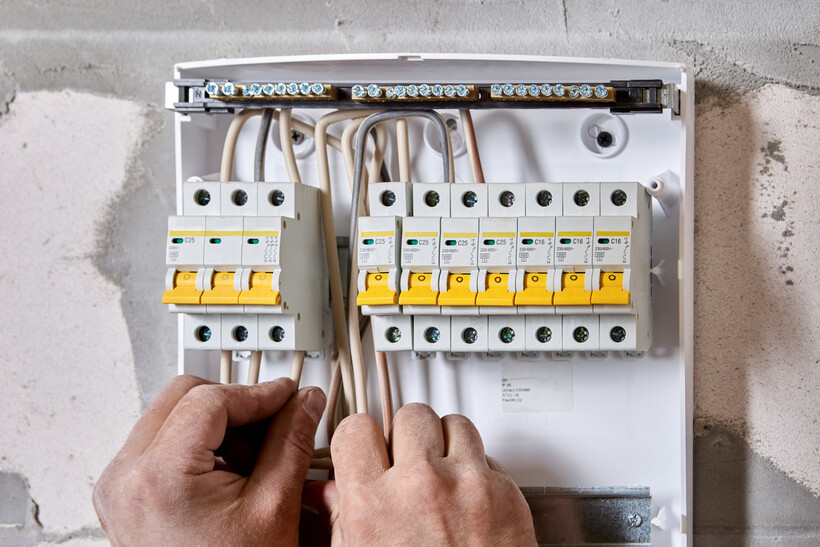 Electrician installing a new consumer unit switchboard fitted with circuit breakers. - how to use switchboard