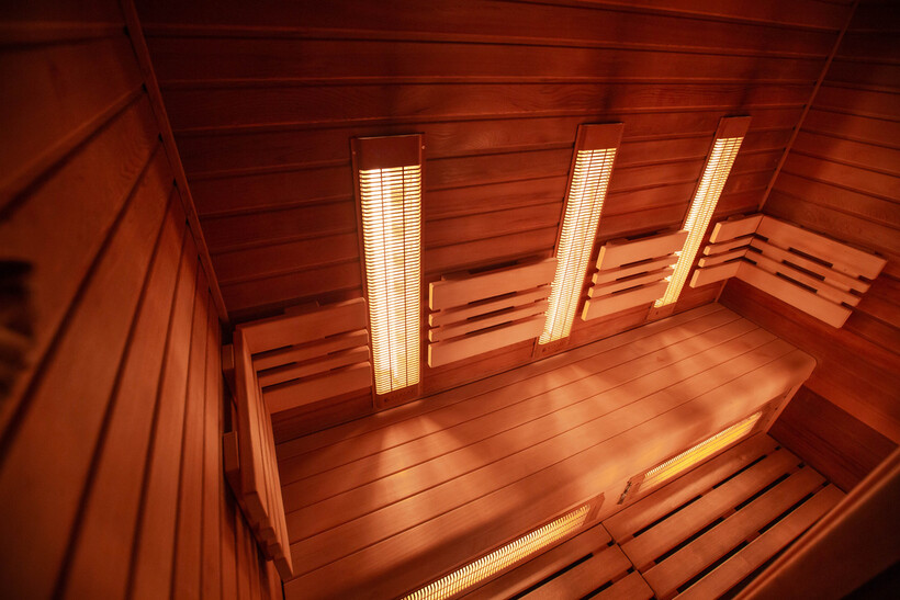 Warm cedar-toned infrared sauna interior with panel heaters mounted on the walls. - infrared vs traditional sauna
