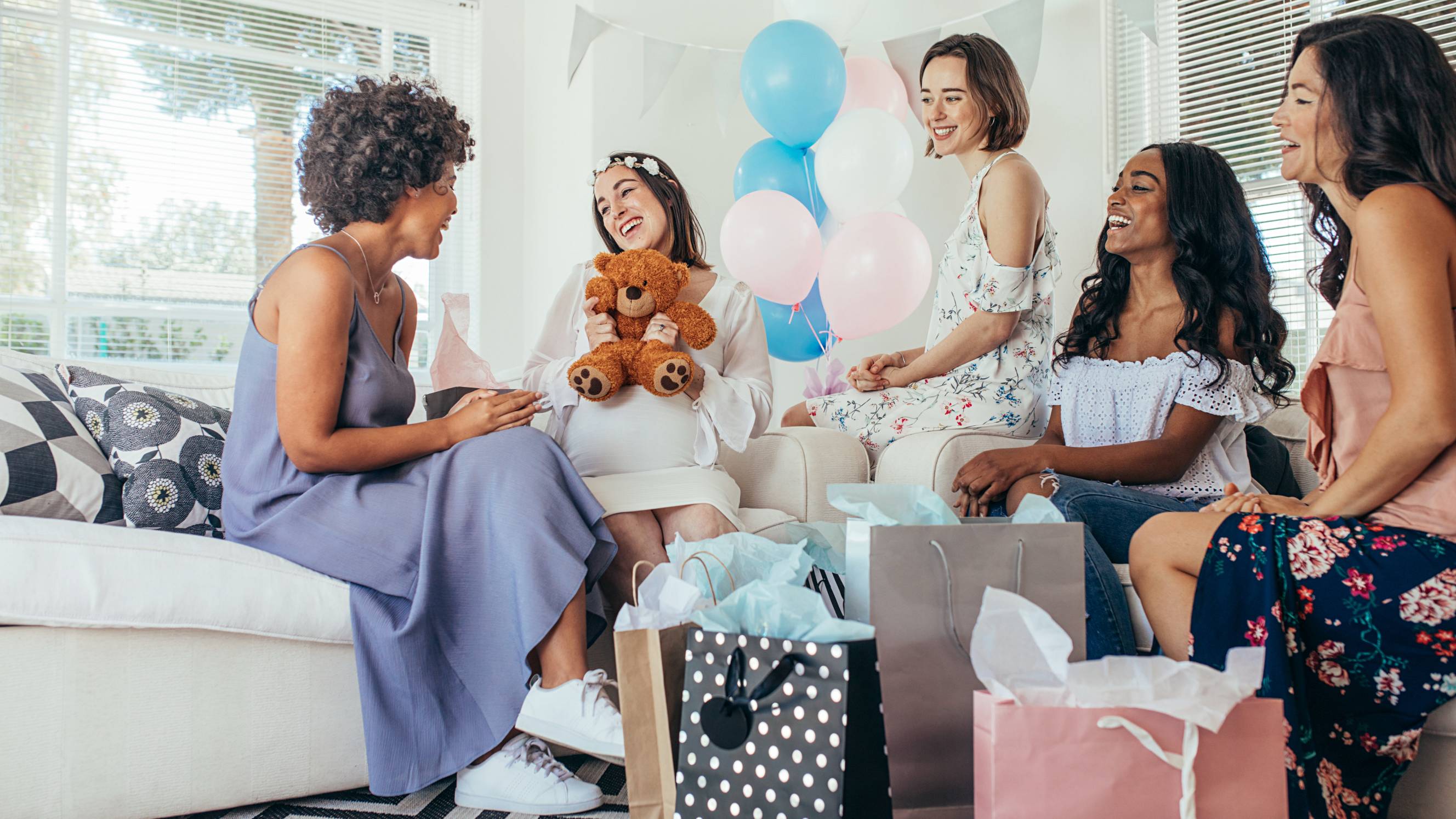 an expecting mother surrounded by her friends during her baby shower