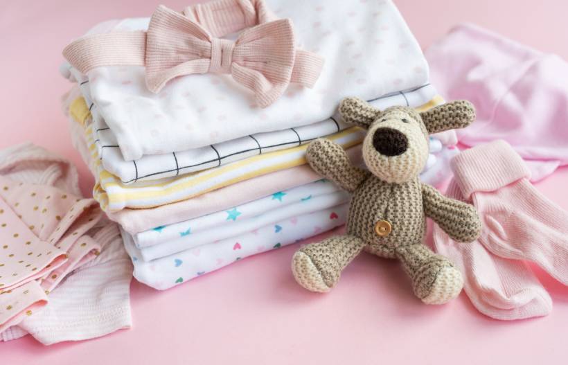 baby shower gift ideas - Pastel baby clothes with crochet stuffed dog and pink bow
