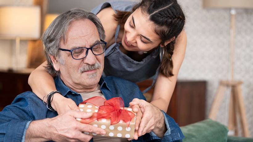 Father's Day gift ideas - Daughter giving her father a wrapped present at home