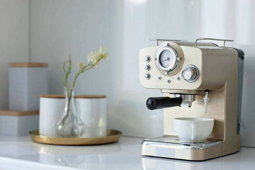 wedding gift ideas - Cream espresso machine with white coffee cup on kitchen counter
