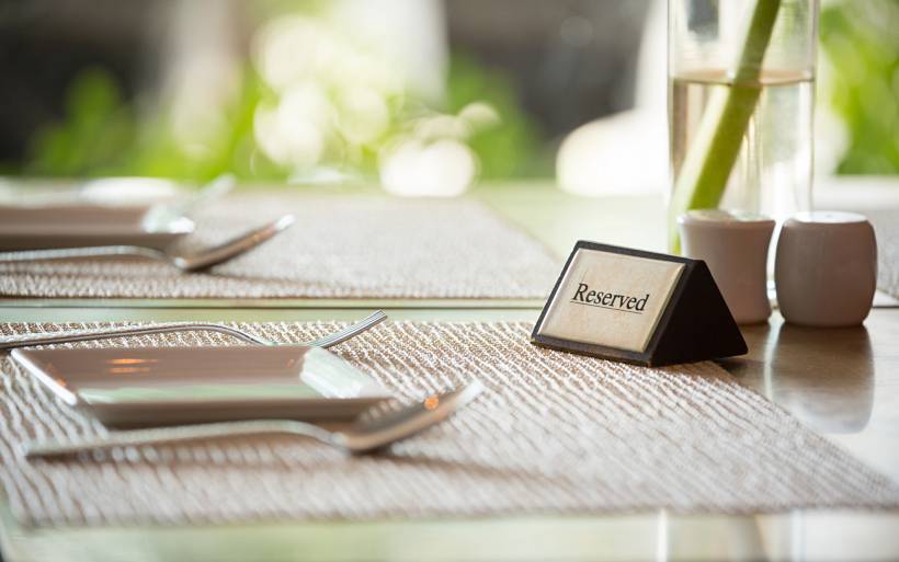 wedding gift ideas - Reserved restaurant table with plates, cutlery, and table decor