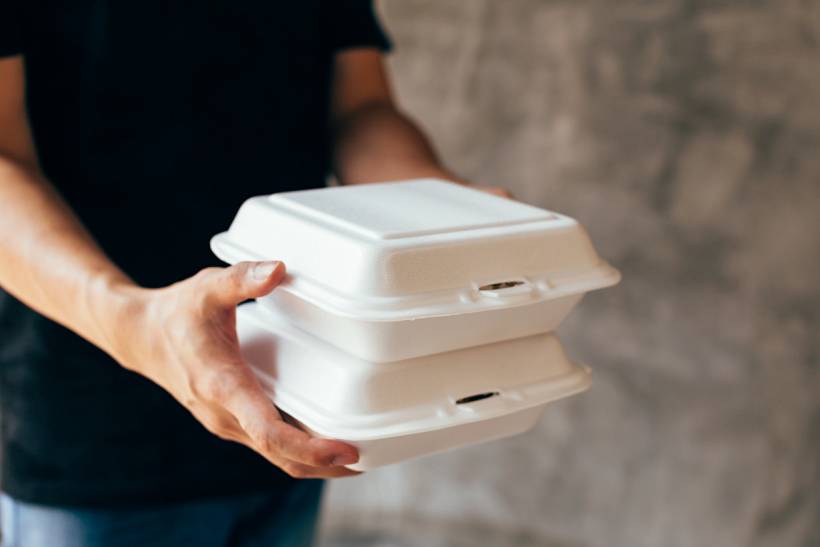wedding gift ideas - Two white takeout containers held by a person indoors