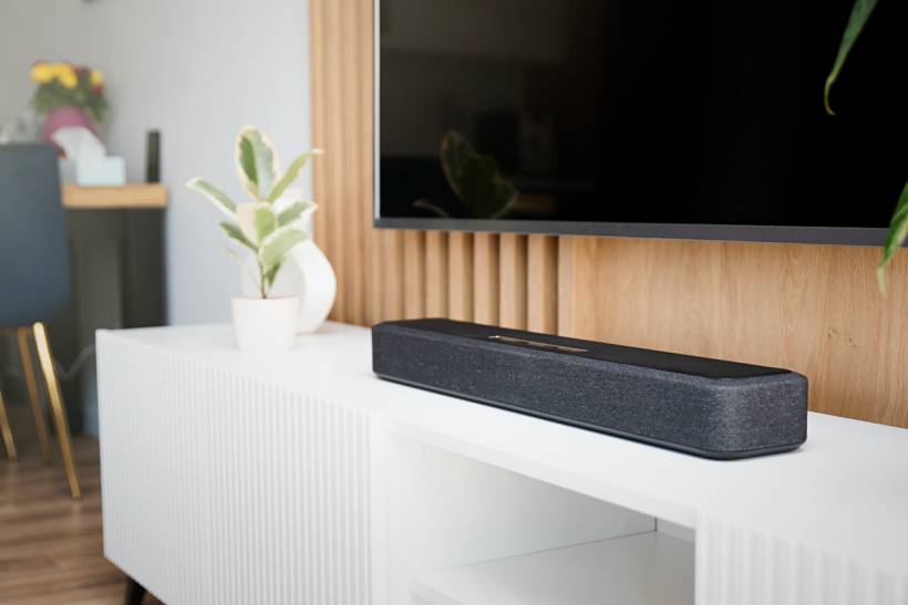 wedding gift ideas - Modern TV setup with black soundbar, wooden paneling, and potted plant