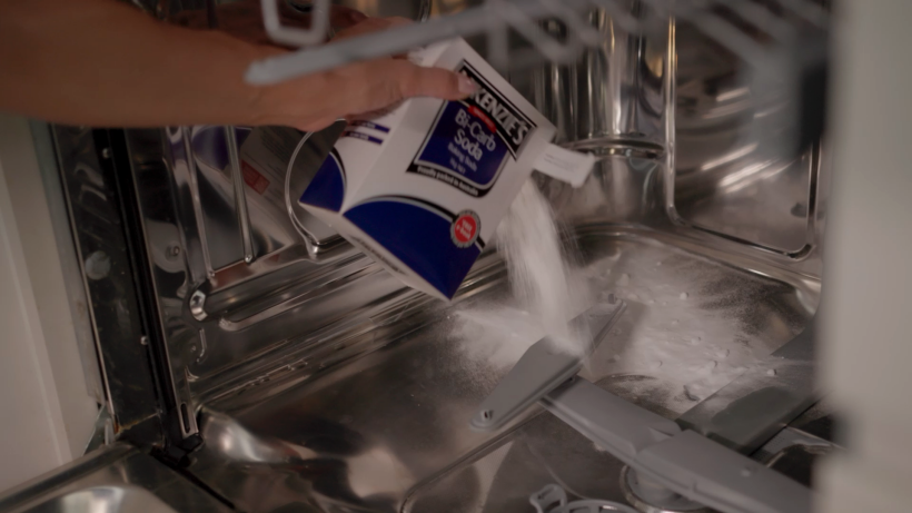 sprinkling a bi-carb soda in a dishwasher to clean it - how to clean a dishwasher
