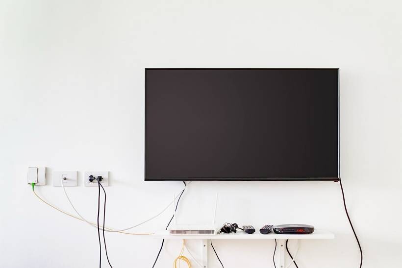 how much does it cost to wall mount a tv - Wall-mounted television above a shelf with connected devices and wiring