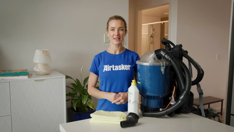 professional cleaner with aircon cleaning tools and supplies in front of her on a table - how to clean ac