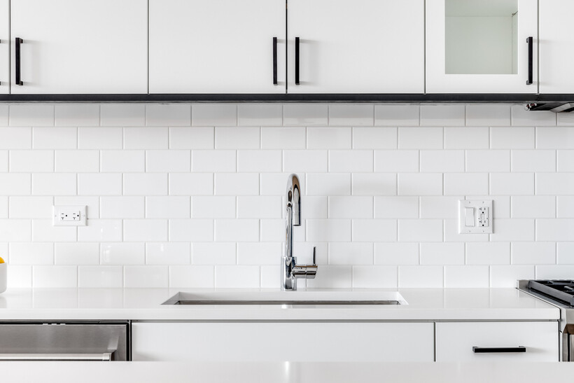Traditional brick-bond white subway tile splashback behind a kitchen sink. - kitchen splashback ideas