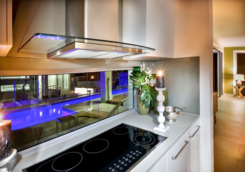 Reflective glass panel behind a cooktop. - kitchen splashback ideas