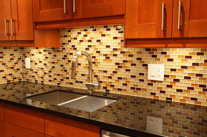 Mixed amber, cream, and brown mosaic tile splashback paired with timber cabinetry. - kitchen splashback ideas