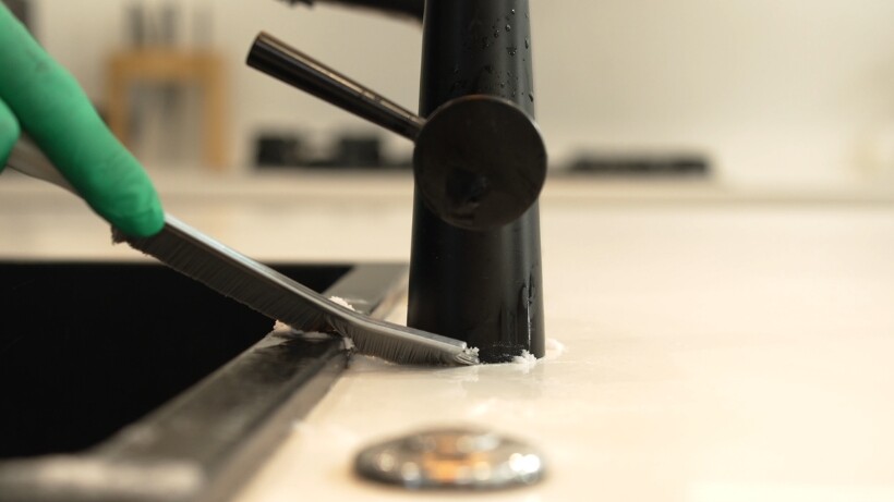 Scrubbing the base of the tap