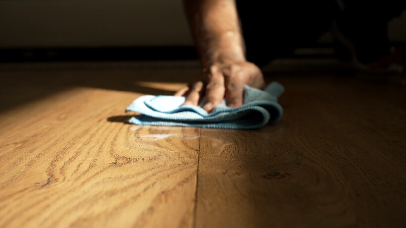 Drying a wooden floor with a microfibre mop